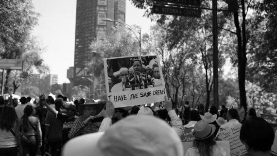 Black-and-white photo of a protest. A sign in the crowd reads "I have the same dream," with Martin Luther King Jr.s' image on it.