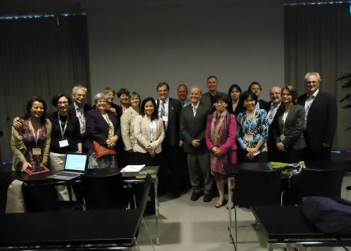 Photo of Stephen Fawcett with a large group of people in a conference room.