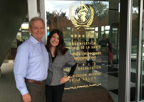 Photo of Stephen Fawcett and Christina Holt in front of the WHO Headquarters in Geneva.