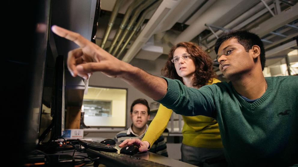 Multi-racial students in front of a computer monitor.