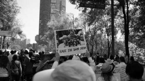 Protest crowd holing a sign with Martin Luther King, Jr. on it, saying "I have the same dream."